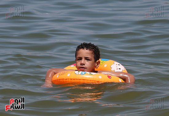 طفل يسبح بالعوامة فى البحر