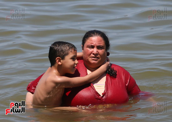 طفل يتشبس بعنق أمه فى البحر