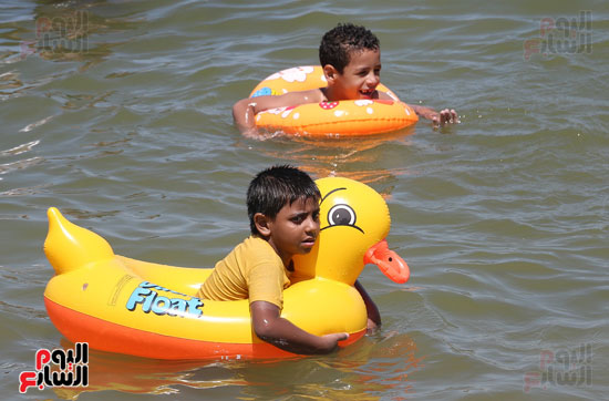 أطفال يسبحون بالعوامات فى البحر