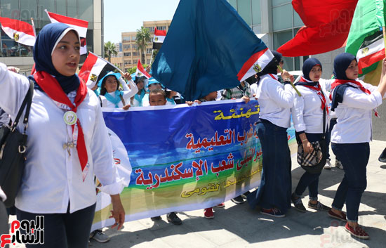 بنات الكشافة بالأعلام المصرية يتقدمون مسيرة احتفالا بعيد الإسكندرية القومى