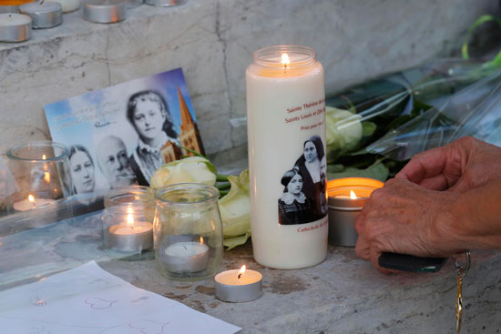 مواطن فرنسى يقوم بإشعال شمعة على روح ضحايا الحادث 
