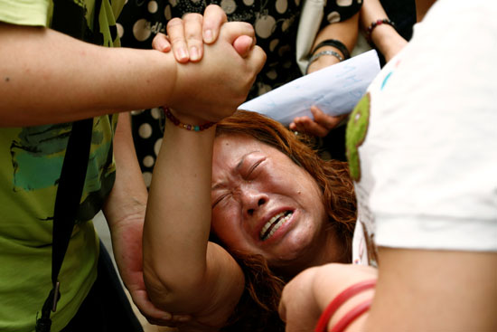 إحدى أقارب ضحايا الطائرة المنكوبة تبكى حزنا من أجل عدم التوقف عن البحث عن الطائرة 