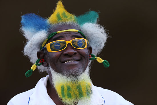 شخص يرتدى نظارة عليها علامة الأولمبياد ويزين شعره بعلم البرازيل