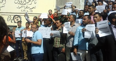 حملة الماجستير يحملون علم مصر خلال تظاهرهم أمام مجلس الوزراء