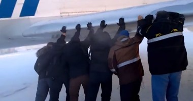 بالفيديو.. ركاب طائرة روسية يدفعونها بأيديهم بسبب تجمدها