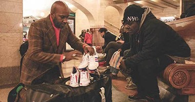 بالصور.. متطوع أمريكى يجول أنحاء نيويورك لتقديم أحذية للمتشردين مجانا