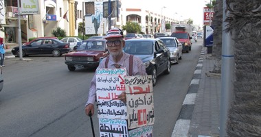 بالصور.. مسن ببورسعيد ينظم مسيرة بمفرده ويرفع لافتة "لن أخون ثورة يناير"