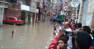 بالصور.. سباق أهالى "الزوايدة" بالإسكندرية على صيد القراميط من مياه الأمطار