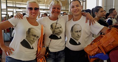بالصور.. سياح روس يرتدون "تيشرتات بوتين" خلال مغادرتهم شرم الشيخ