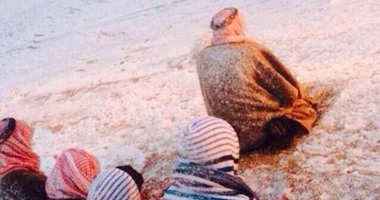 تداول صورة لأب وأبنائه يؤدون الصلاة فى العراء رغم تساقط الثلوج
