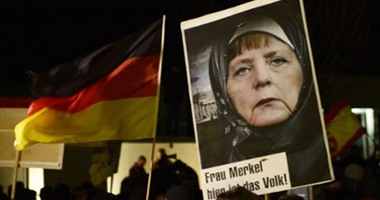 متظاهرون يرفعون صورة لميركل بالحجاب فى ألمانيا
