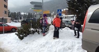 أطفال منتجع "دافوس" يلهون بكرات الثلج بالقرب من المؤتمر الاقتصادى