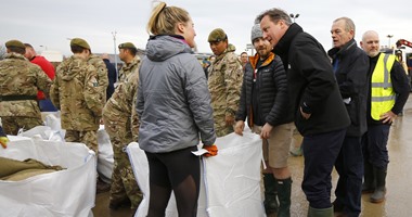 بالصور.. "كاميرون" يقدم مساعدات  للمتضررين من الفيضانات ببريطانيا