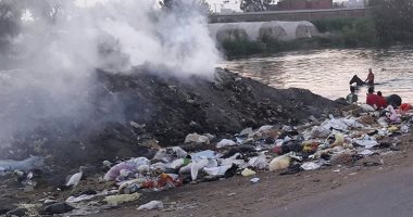 بالصور.. موظفو الوحدة المحلية فى نبروة يحرقون القمامة على ضفاف النيل 