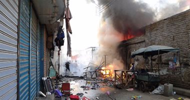 بالصور.. إخماد حريق بمبنى وسط سوق الخضار فى نجع حمادى