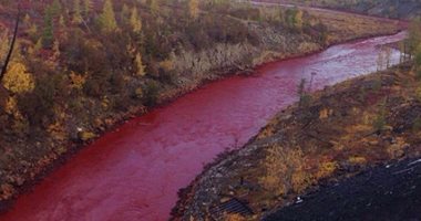 بالصور.. نهر روسى يتحول للون "الدماء"