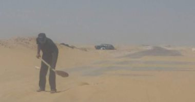 بالصور.. "مسعف" يزيل الكثبان الرملية من طريق بالوادى الجديد منعا للحوادث