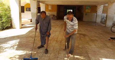 مدير مدرسة وعدد من المدرسين ينظفون آثار السيول فى أسيوط