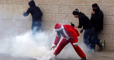 بالصور.. فلسطينيون فى زى بابا نويل يشتبكون مع قوات الاحتلال الإسرائيلى