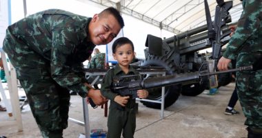 أطفال تايلاند يحتفلون فى ذكرى يومهم بالأسلحة والمصفحات