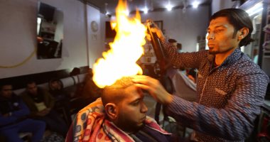 بالصور.. النار أغرب وسيلة لتصفيف الشعر وفرده فى قطاع غزة 