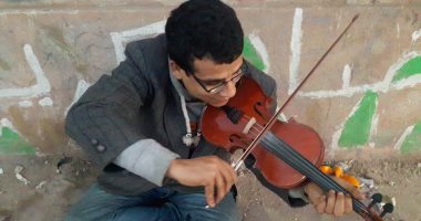 بالفيديو والصور.. شاب يتحدى إعاقته بعزف الكمان على كورنيش الإسكندرية