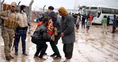 بالصور.. النازحون العراقيون يشقون طريقهم للمخيمات وسط هطول الأمطار