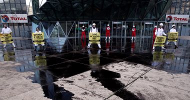 بالصور.. نشطاء منظمة السلام الأخضر يتظاهرون أمام شركة النفط الفرنسية "توتال"