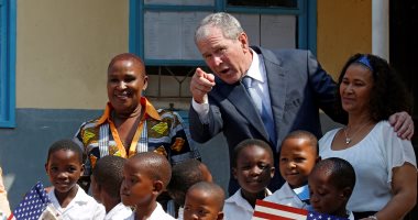 جورج بوش يزور مدرسة فى جابورون.. والطلاب يستقبلونه بالعلم الأمريكى