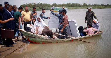 بالصور.. هروب سكان الموصل من الحرب والفيضانات على متن مراكب متهالكة