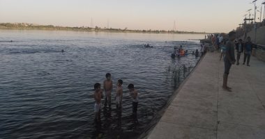 بالصور.. شاطئ النيل يستقطب الصائمين بإدفو للسباحة فى النهر قبل الغروب