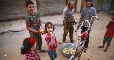 بالصور.. أطفال سوريون يتناولون الذره المشوى بالغوطة بعد توقف الاشتباكات