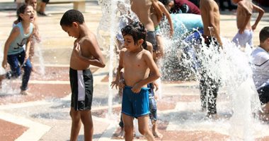 أطفال يحولون نافورة حديقة الأزهر لحمام سباحة هربا من حرارة الجو 