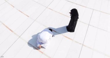 سعودى يصلى فى ظل زوجته بساحة الحرم المكى للوقاية من حرارة الشمس