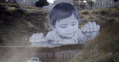 صورة عملاقة لطفل فوق الجدار بين المكسيك وأمريكا تفتح النقاش حول الهجرة