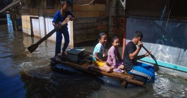صور.. مواطنو إندونيسيا يستخدمون المراكب فى الشوارع بسبب الفيضانات