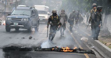 جنود هندوراس يزيلون أثار اشتباكات أنصار المعارضة والشرطة 