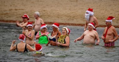 صور.. مواطنون يسبحون بزى سانتا كلوز فى البحر احتفالا بالكريسماس بألمانيا