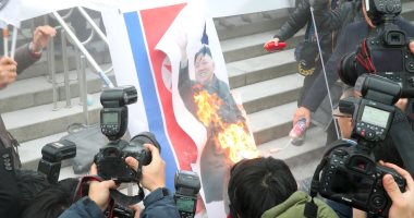 صور.. متظاهرون يستقبلون وفد كوريا الشمالية فى سول بحرق لافتات زعيمهم 