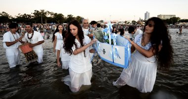 صور.. مواطنون فى الأوروجواى يقدمون الورود لـ"آلهة البحر" طلبًا للبركة والخير