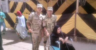 صور.. رجال الجيش يساعدون عجوز للإدلاء بصوتها فى حدائق حلوان