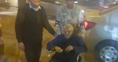 أفراد الأمن يحملون مسنا على كرسى متحرك للإدلاء بصوته فى الدقى