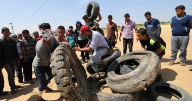 صور.. شبان فلسطينيون يشعلون النيران فى إطارات السيارات على حدود غزة