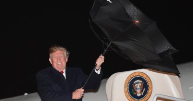 صور.. "ترامب" يفقد السيطرة على مظلته بعد صراع مع الرياح