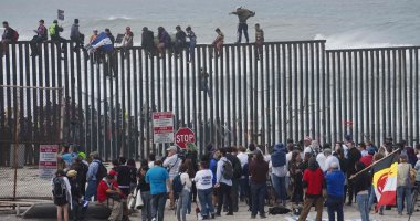صور.. مهاجرون يتحدون ترامب ويقفزون فوق الجدار الحدودى بين أمريكا والمكسيك