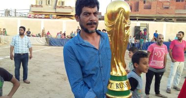 صور.. نجار من دمياط يصنع نسخة خشبية من كأس العالم