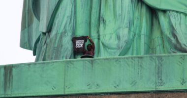 صور.. بعد ساعات من التفاوض.. شرطة نيويورك تعتقل امرأة تظاهرت فوق تمثال الحرية
