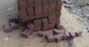 صور..شكوى من تغطية بالوعات الصرف أثناء عمل الأسفلت فى شارع العشرين 