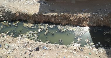 صور.. شكوى من وجود مصرف لمياه الصرف الصحى يمر وسط قرية العادل بالفيوم  
