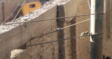 مواطن يربط عامود إنارة فى السور خشية سقوطه على المارة بالجيزة